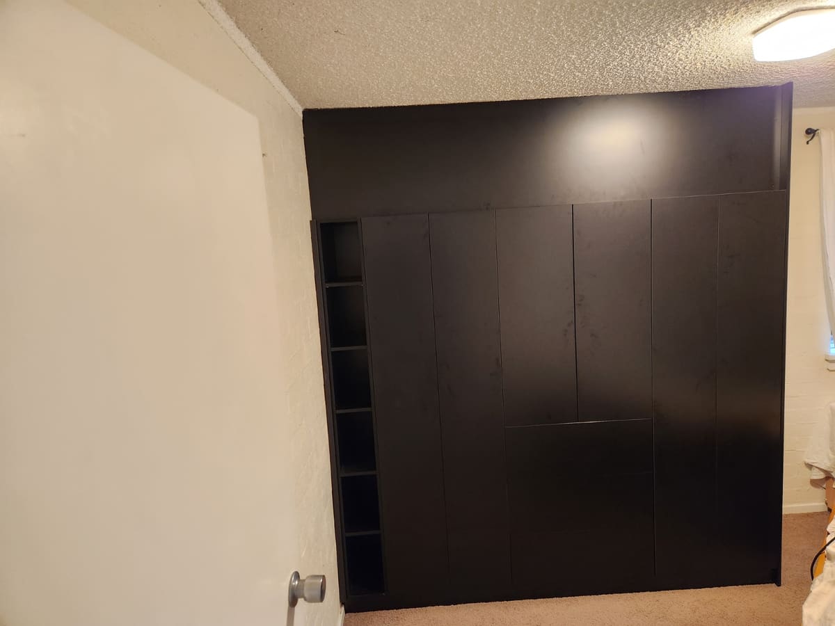 Built-in wardrobe over exposed pipework after